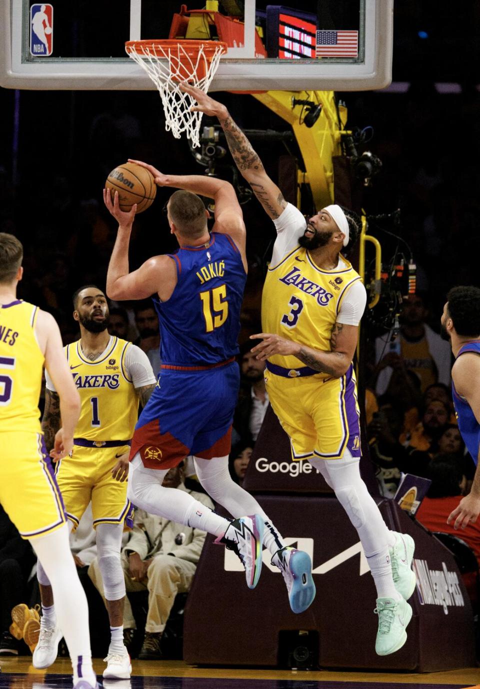 Lakers forward Anthony Davis, right, tries to block a shot by Denver Nuggets center Nikola Jokic.