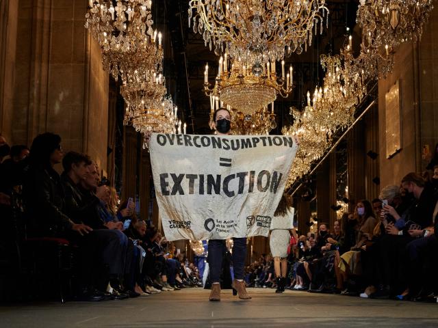 Protestor on Louis Vuitton SS22 Runway Show