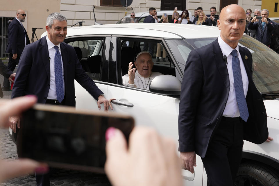 Pope Francis waves from his car as he arrives at The Vatican, Saturday, April 1, 2023 after receiving treatment at the Agostino Gemelli University Hospital for a bronchitis, The Vatican said. Francis was hospitalized on Wednesday after his public general audience in St. Peter's Square at The Vatican. (AP Photo/Andrew Medichini)