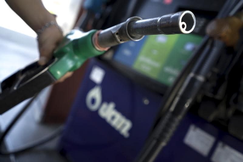 A worker grabs a nozzle at a PTT gas station in Bangkok, Thailand, January 5, 2016. REUTERS/Athit Perawongmetha