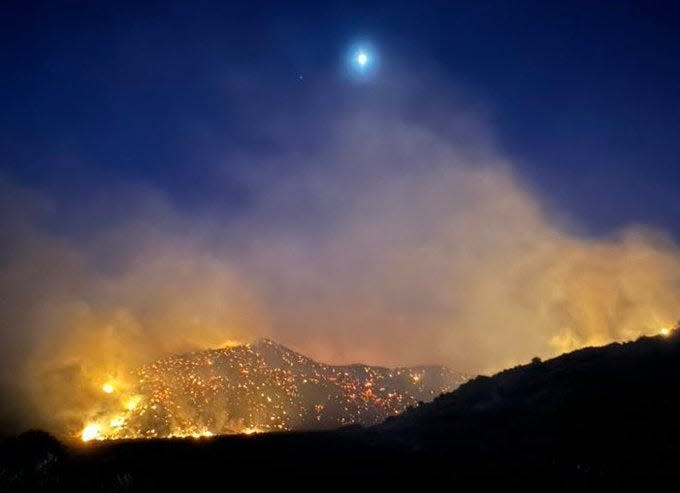 The moon shines over the Post Fire early Sunday burning between Gorman and Pyramid Lake.