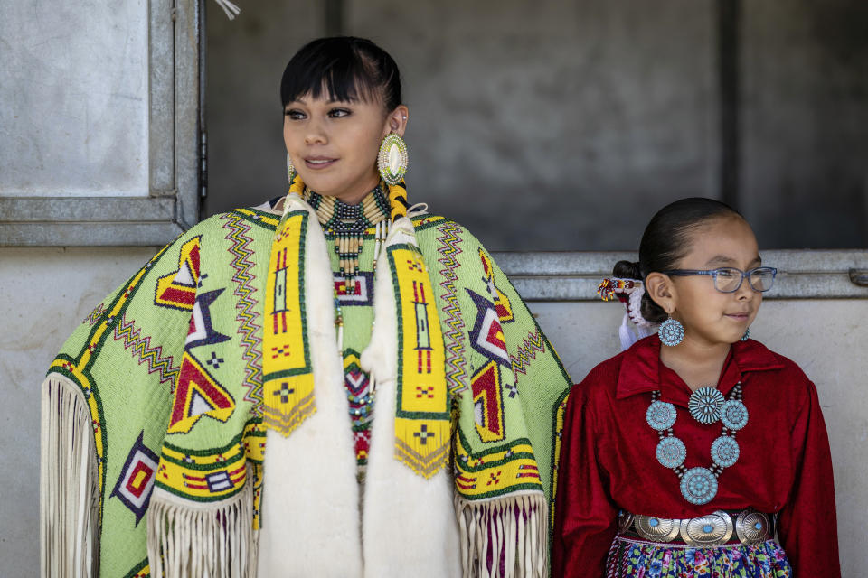 Shantal Sandoval,left, and her eight year-old daughter Chanel Yazzie, of To'hajiilee, New Mexico prepare to participate in a horse parade at the 40th anniversary of the Gathering of Nations Pow Wow in Albuquerque, N.M., Friday, April 28, 2023. Tens of thousands of people gathered in New Mexico on Friday for what organizers bill as the largest powwow in North America. (AP Photo/Roberto E. Rosales)