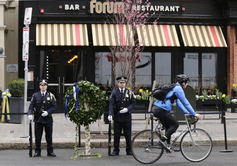 A Boston Police honor guard is posted outside the Forum restaurant, the site of the second of two bombs that exploded near the finish line of the 2013 Boston Marathon, Tuesday, April 15, 2014 in Boston. Three were killed and more than 260 injured in last year's explosions near the finish line of the race. (AP Photo/Charles Krupa)