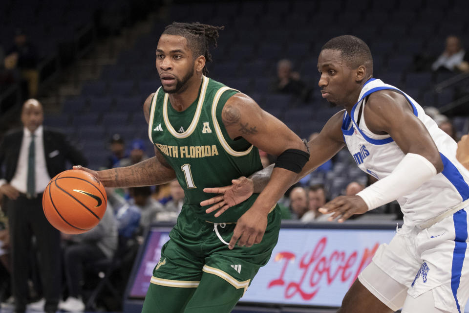 South Florida guard Selton Miguel (1) dribbles the ball next to Memphis forward David Jones during the first half of an NCAA college basketball game Thursday, Jan. 18, 2024, in Memphis, Tenn. (AP Photo/Nikki Boertman)