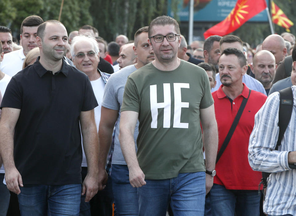 Hristijan Mickoski, center, the leader of the biggest opposition VMRO-DPMNE party surrounded by supporters marches through a street during a protest in Skopje, North Macedonia, on Wednesday, July 6, 2022. Thousands of people were marching the fifth night of protests in North Macedonia's capital after French President Emmanuel Macron last week announced the proposal, which many in the small Balkan country find controversial. (AP Photo/Boris Grdanoski)