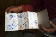 Alejandro Perez, 31, shows his Saint James pilgrim's credential after receiving a stamp at the end of a stage in Najera, near Pamplona, northern Spain, Thursday, April 15, 2021. The pilgrims are trickling back to Spain's St. James Way after a year of being kept off the trail due to the pandemic. Many have committed to putting their lives on hold for days or weeks to walk to the medieval cathedral in Santiago de Compostela in hopes of healing wounds caused by the coronavirus. (AP Photo/Alvaro Barrientos)