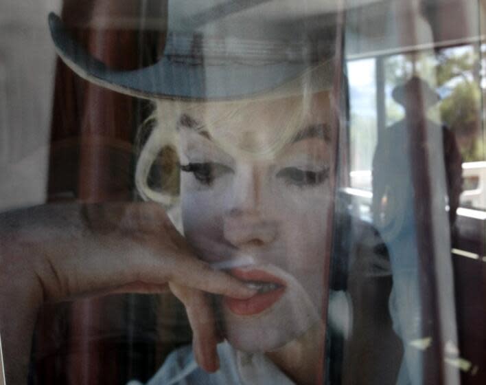 Schaben, Allen J. –– – LAKE TAHOE, NEVADA – May 22, 2009: Tour guide Carl Buehler is reflected in a photo of Marilyn Monroe hanging in cottage @@#3 at the historic Cal Neva Resort, Spa and Casino once owned by Frank Sinatra, which she frequented and was reported to have overdosed in shortly before her death in Brentwood, California. The Cal Neva was up for auction and nobody wanted it. It fell into foreclosure after its most recent ex–owner was forced into bankruptcy by members of L.A.'s Persian Jewish community. Cal Neva managert Bob Marcil is working hard to bring in new talent and show off the underground tunnels that Sinatra used to hustle mobsters and celebs around the place, the showroom he built, Marilyn Monroe's cottage, etc.. (Allen J. Schaben/Los Angeles Times)