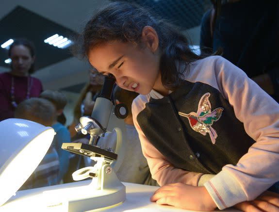 A girl looks through a microscope during the 2016 Russian Festival of Science in Moscow.