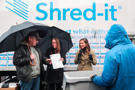 A couple participates in the National Good Riddance day ceremonial shredding of bad memories of 2018 in Times Square in the Manhattan borough of New York, U.S., December 28, 2018. REUTERS/Jeenah Moon