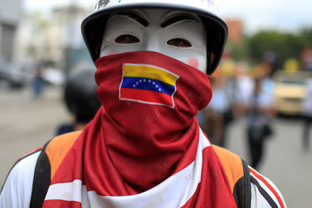 An opposition supporter wearing a Guy Fawkes mask takes part in a protest against upcoming presidential elections, in Caracas, Venezuela May 16, 2018. REUTERS/Marco Bello