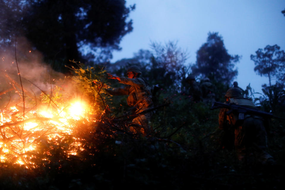 A soldier burns an illegal opium plantation