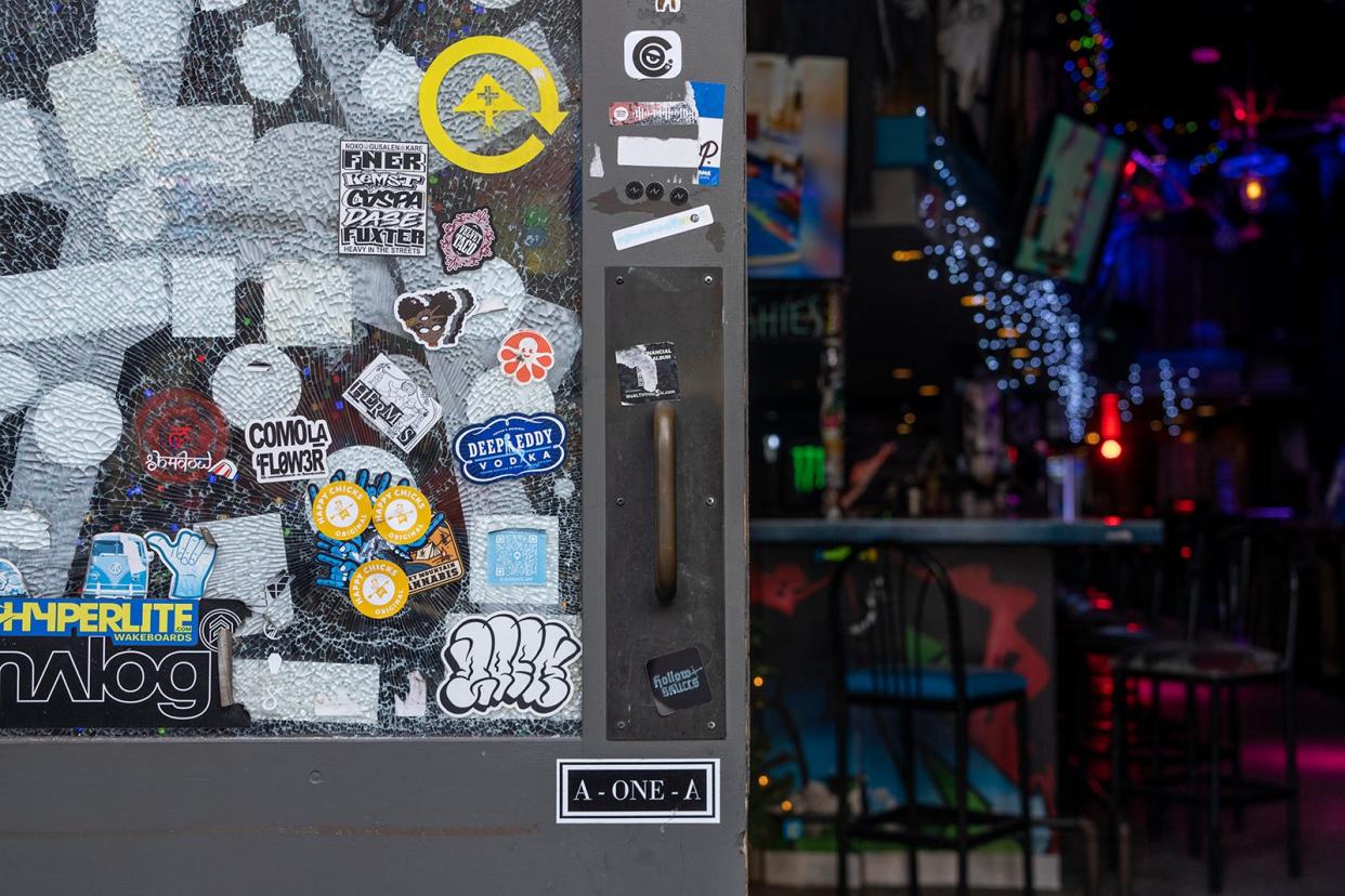 Stickers cover up a bullet hole that went through the window at Gnar Bar on 6th Street Tuesday, Dec.19, 2023. The bullet hole went through during an officer-involved shooting the night of Saturday, Dec. 16, 2023.