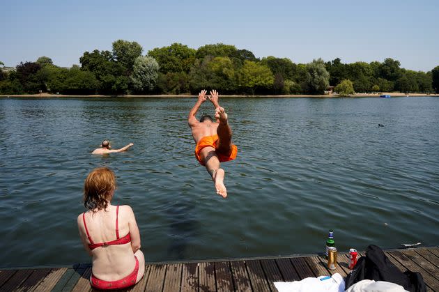 A man jumps into the Serpentine lake to cool off in Hyde Park, west London. (Photo: NIKLAS HALLE'N via Getty Images)