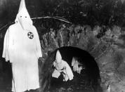 <p>Members of the American white supremecist movement, the Ku Klux Clan crawling out of a tunnel after a meeting in 1922. (Photo: Topical Press Agency/Getty Images) </p>