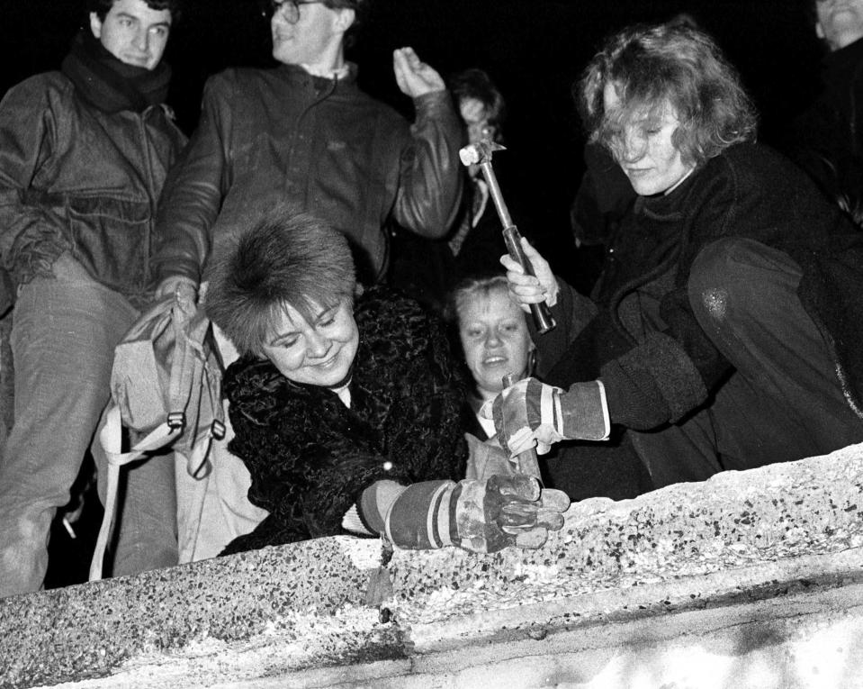 Berliners take a hammer and chisel to a section of the Berlin Wall in front of the Brandenburg Gate after the opening of the East German border was announced in this  Nov. 9, 1989. (Photo: Fabrizio Bensch/Reuters)