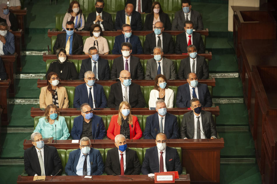 Tunisian designated Prime Minister Hichem Mechichi, first row at right, sits with members of his cabinet at the parliament before a confidence vote in Tunis, Tuesday, Sept. 1, 2020. (AP Photo/Riadh Dridi)