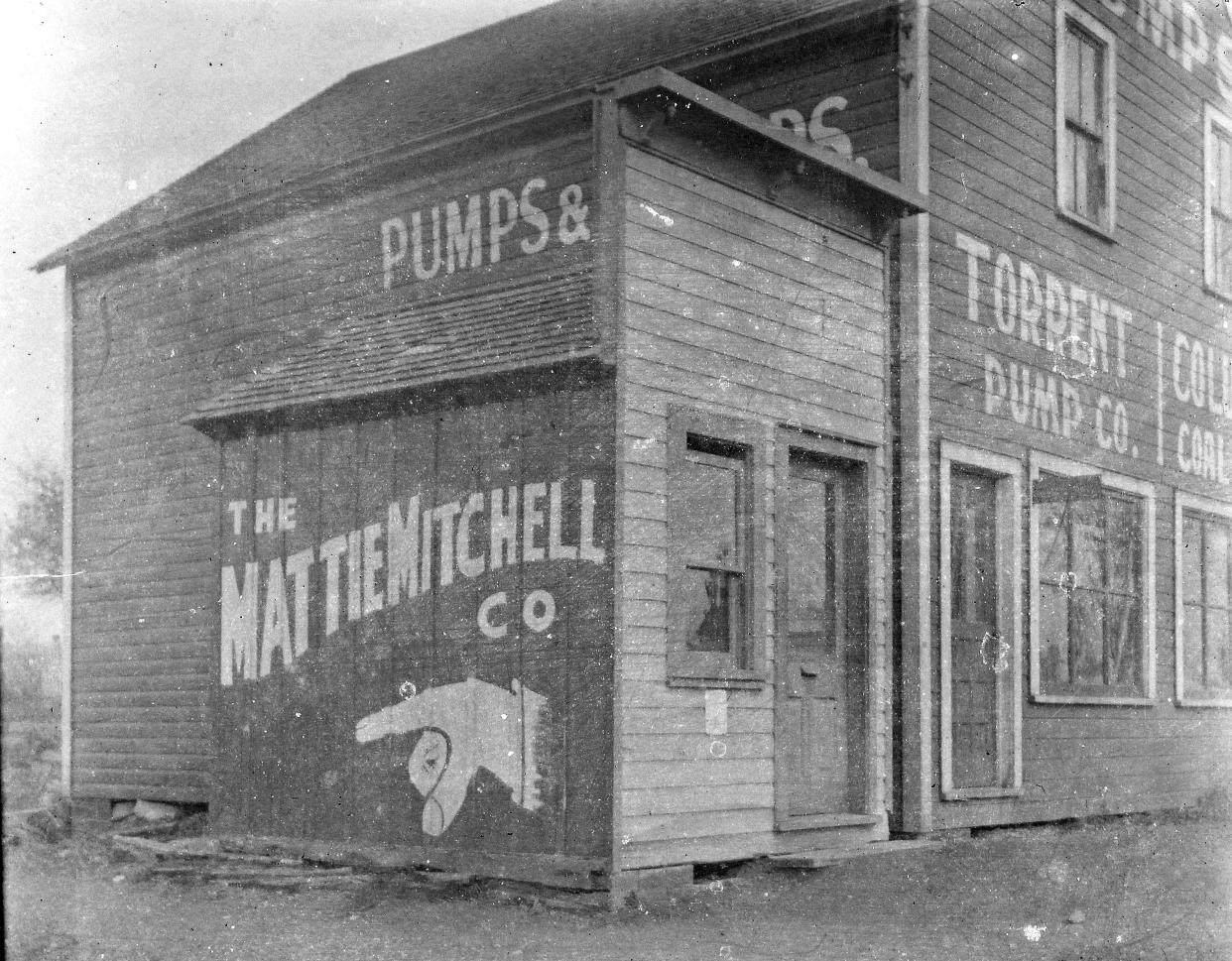 Corporate logos for the Mattie Mitchell Co. and the Torrent Pump Co. are painted on a wooden building on Harvard Avenue in Cleveland.