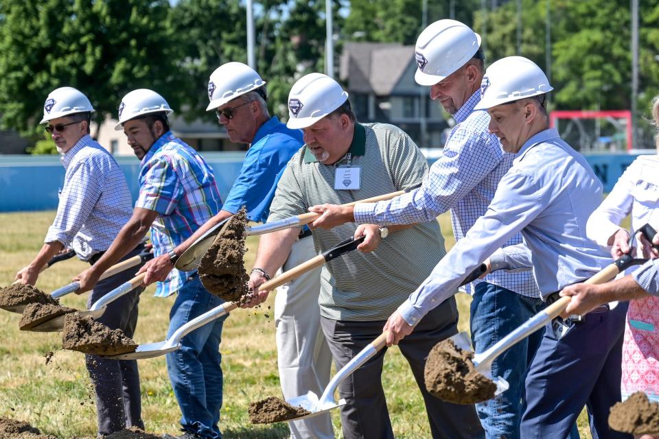 Founder Jeff Lazaros, center, MLB Hall of Famer and Lansing native John Smoltz, to the right, Mayor Andy Schor, to Smoltz's right, and other officials shovel dirt during a groundbreaking ceremony for the John Smoltz Strikeout Baseball Stadium on Tuesday, June 28, 2022, at Ferris Park in Lansing.