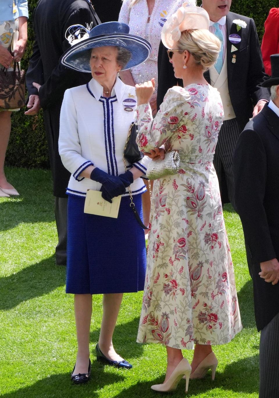 Princess Anne, wearing a blue skirt and coordinating top, standing next to Zara Tindall.