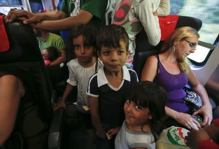 Children stand among seats in a train with migrants on board, en route from Budapest to Vienna, Austria, August 31, 2015. REUTERS/Laszlo Balogh