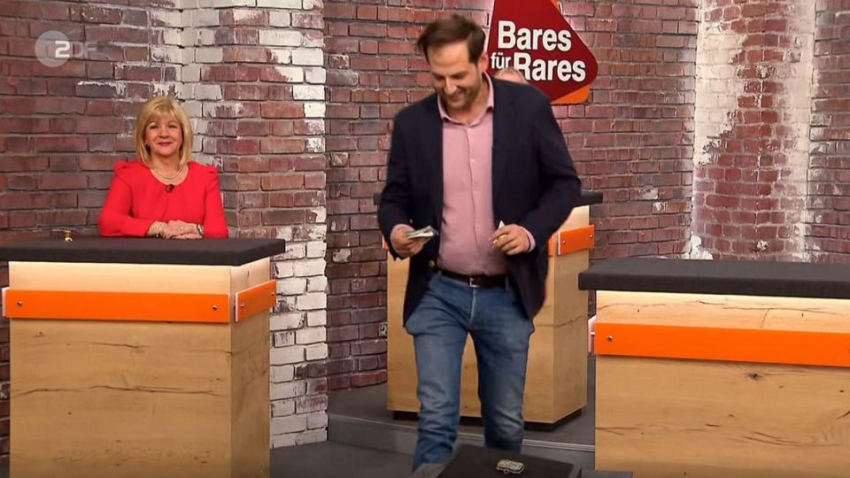 "Ich finde es kurios", deshalb machte Julian Schmitz-Avila ein Startangebot, das niemand sonst überbieten wollte. 90 Euro legte er auf den Tisch. (Bild: ZDF)