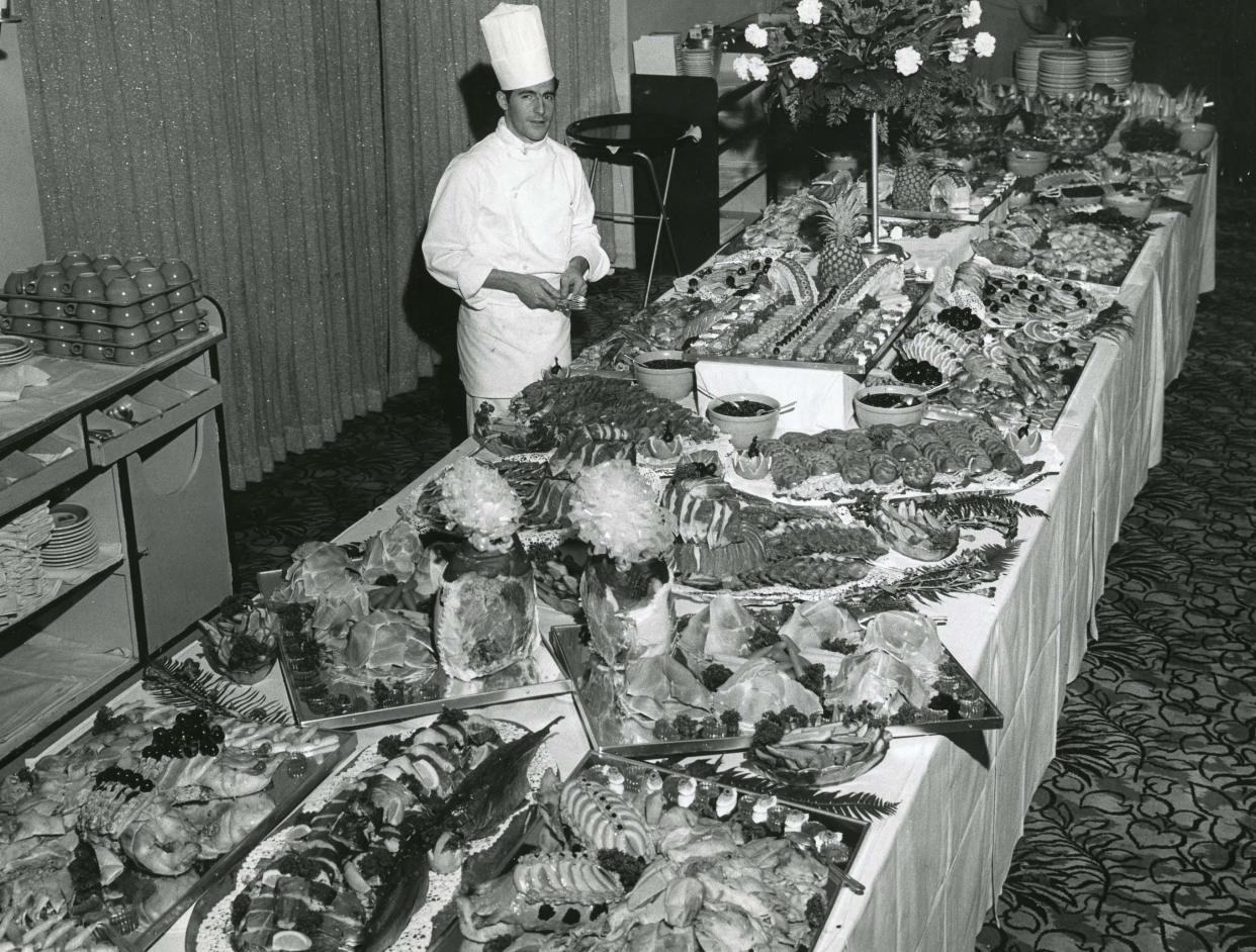 Werner Futterer standing behind a lavish buffet that he regularly created for guests and residents alike.