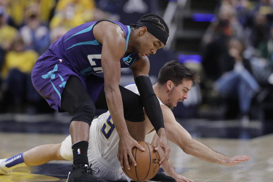 Charlotte Hornets' Devonte' Graham (4) recovers the ball against Indiana Pacers' T.J. McConnell (9) during the second half of an NBA basketball game, Sunday, Dec. 15, 2019, in Indianapolis. (AP Photo/Darron Cummings)