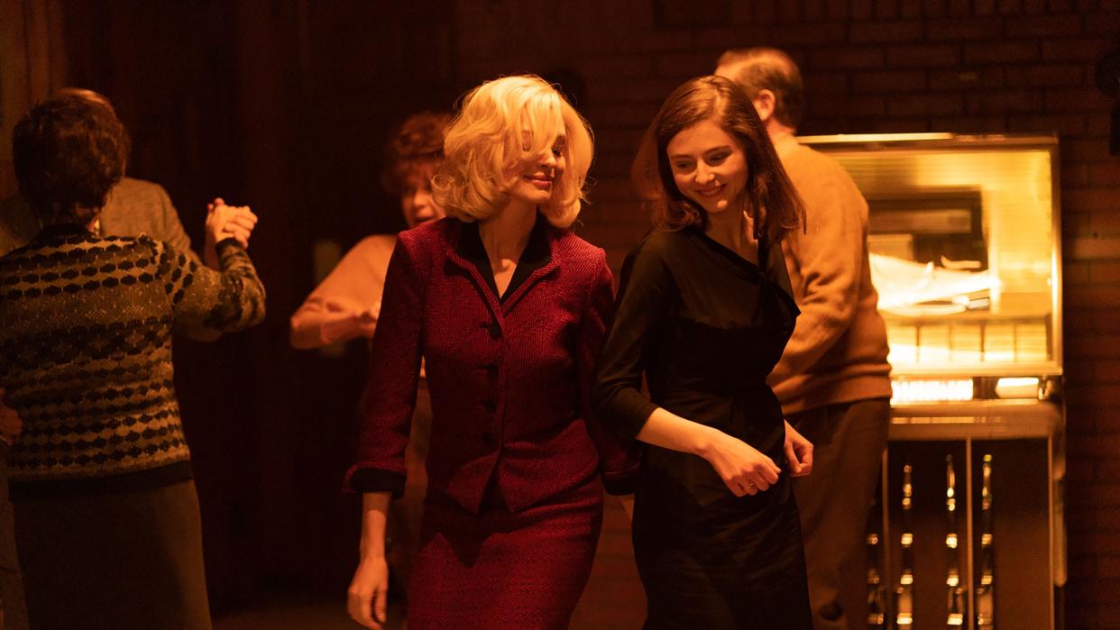 Rebecca (Anne Hathaway, left) and Eileen (Thomasin McKenzie) enjoy a night out on the town in the stylish, 1960s-set thriller "Eileen."