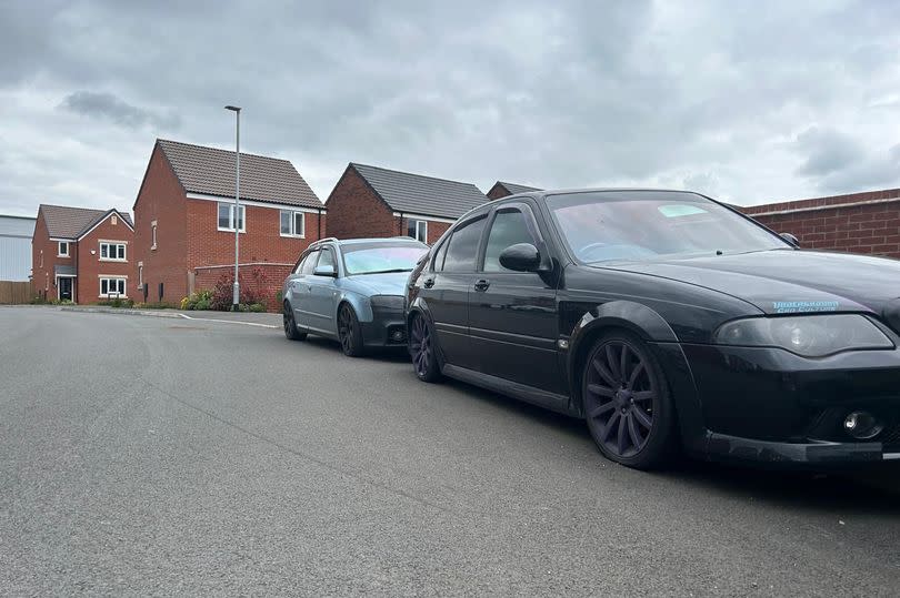 Modified low ride black sedan with purple wheels and low ride light blue Audi parked on pavement on Gadwall Road on the new Rivendell estate in Netherfield/Colwick