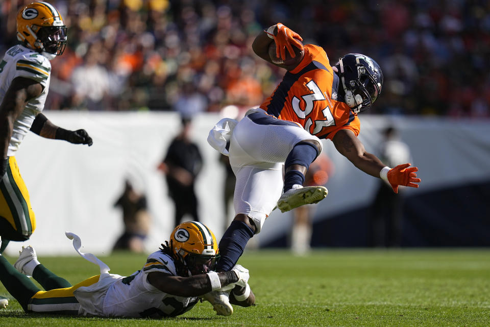 Denver Broncos running back Javonte Williams (33) runs against Green Bay Packers safety Darnell Savage, bottom, during the first half of an NFL football game in Denver, Sunday, Oct. 22, 2023. (AP Photo/Jack Dempsey)