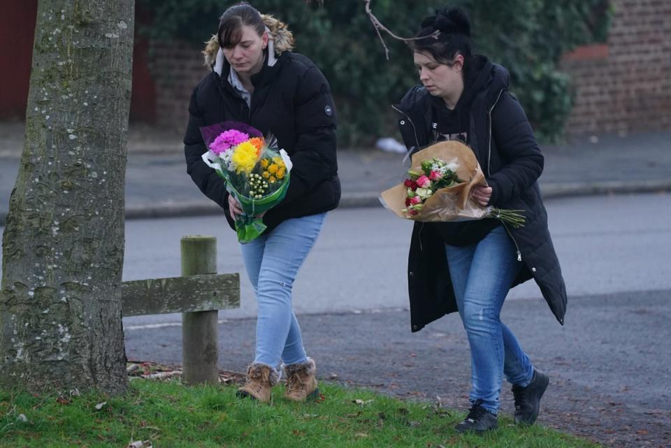 Members of the public lay flowers near to the scene in Babbs Mill Park in Kingshurst, Solihull (PA)