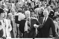 FILE - In this July 13, 1976, file photo, President Gerald Ford throws the ceremonial first pitch to start the Baseball All-Star game in Philadelphia. At right is Baseball Commissioner Bowie Kuhn. (AP Photo)