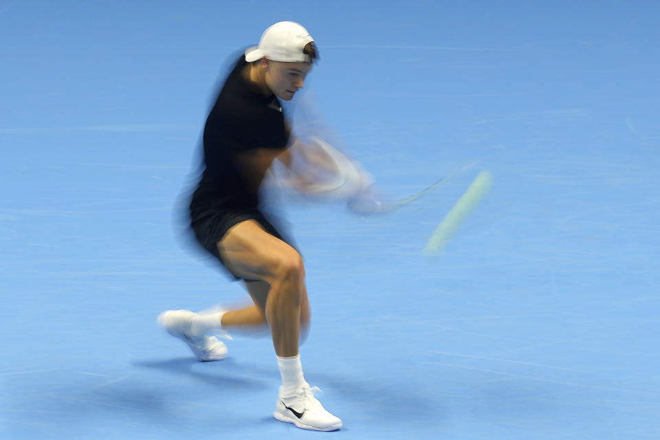 In this image taken with a slow shutter speed, Denmark's Holger Rune returns the ball to Serbia's Novak Djokovic during their singles tennis match of the ATP World Tour Finals at the Pala Alpitour, in Turin, Italy, Sunday, Nov. 12, 2023. (AP Photo/Antonio Calanni)