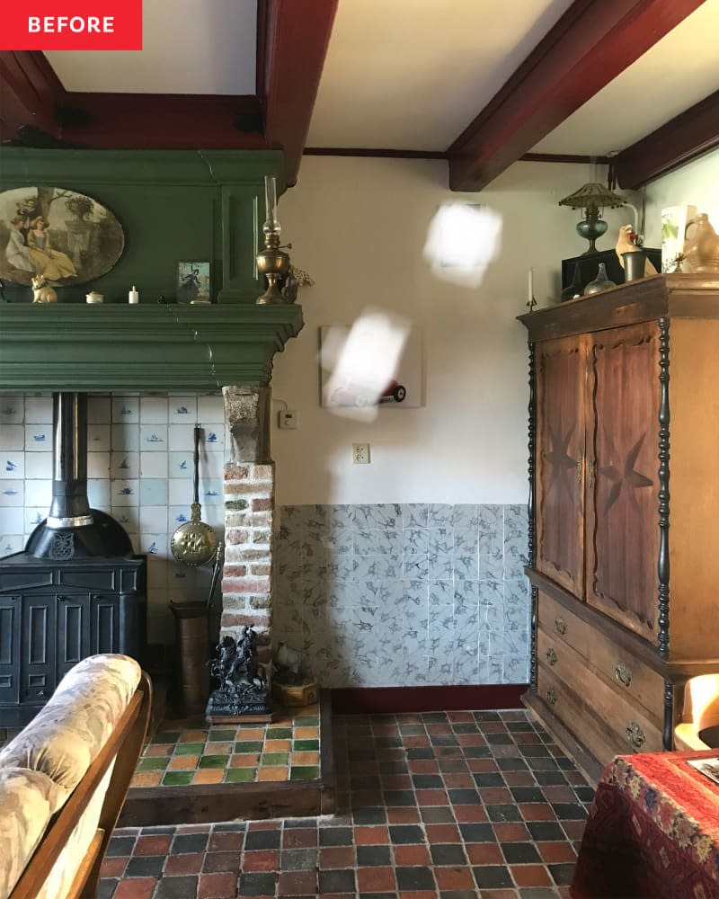 Corner of a kitchen with a fire place and large dresser.