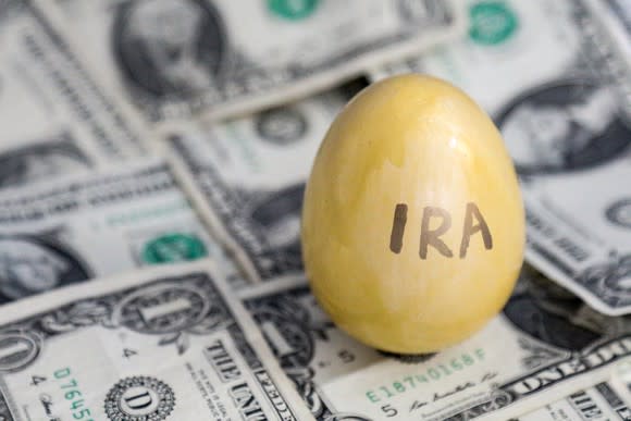 Gold egg with IRA written on it on top of $1 bills