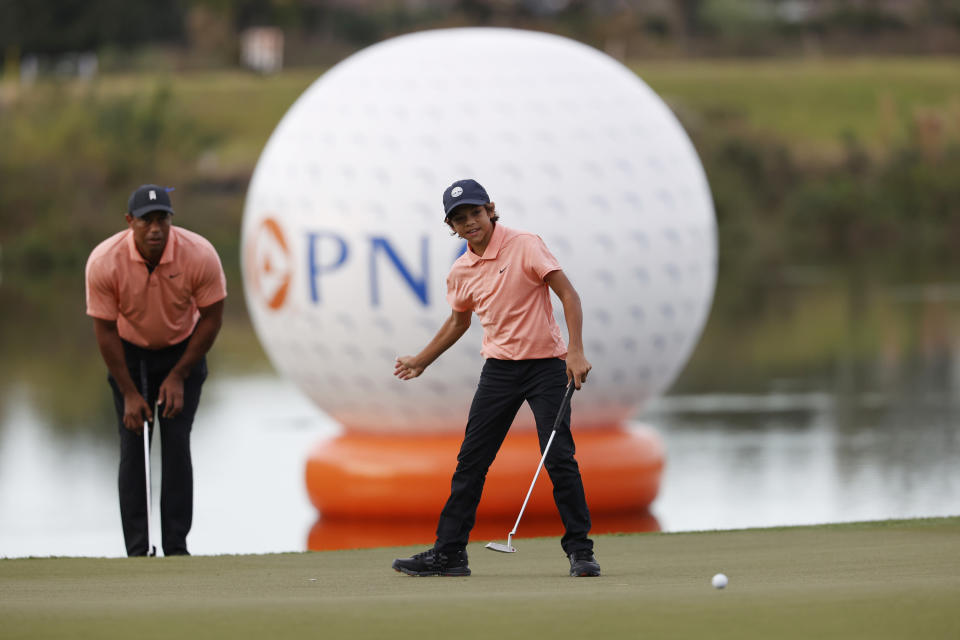 Charlie Woods reacts to missing a putt on 16th green as father Tiger Woods watches during the first round of the PNC Championship golf tournament Saturday, Dec. 18, 2021, in Orlando, Fla. (AP Photo/Scott Audette)