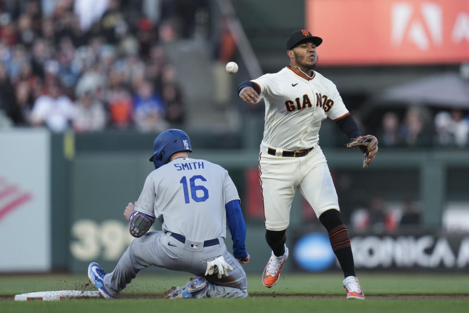 San Francisco Giants shortstop Thairo Estrada, right, throws to first after forcing out Los Angeles Dodgers' Will Smith at second during the first inning of a baseball game in San Francisco, Wednesday, April 12, 2023. Max Muncy was safe at first. (AP Photo/Godofredo A. Vásquez)