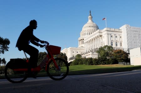 A man rides his bike past the U.S. Capitol Building in Washington