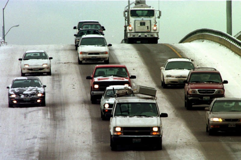 Motorists making their way east down the Vandeventer overpass on Highway 40 go slow as one and a half inches of snow fall on the area January 7, 1999. On January 2, 1974, U.S. President Richard Nixon signed a bill requiring states to limit highway speeds to 55 mph or lose federal highway funds. File Photo by Bill Greenblatt/UPI