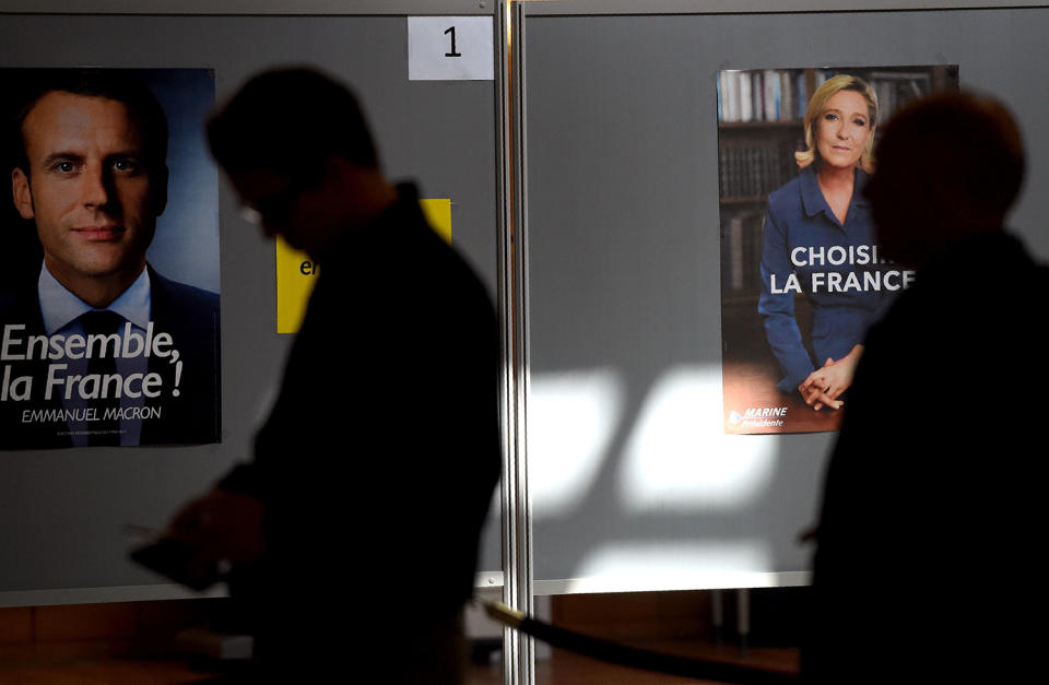 <p>French nationals stand in a line next to posters depicting presidential candidates Emmanuel Macron and Marine Le Pen as they wait to cast their votes at a polling station in the French Embassy in Moscow, May 7, 2017. (Vasily Maximov/AFP/Getty Images) </p>