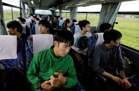 Tourists from Tokyo's universities, look out from a bus at an area devastated by the March 11, 2011 earthquake and tsunami, near Tokyo Electric Power Co's (TEPCO) tsunami-crippled Fukushima Daiichi nuclear power plant, in Namie town, Fukushima prefecture, Japan May 19, 2018. Picture take May 19, 2018. REUTERS/Toru Hanai