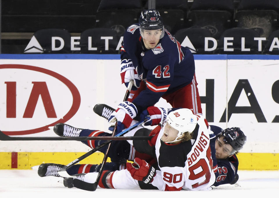 New York Rangers' Brendan Smith (42) and Libor Hajek (25) combine to check New Jersey Devils' Jesper Boqvist (90) during the second period of an NHL hockey game Thursday, April 15, 2021, in New York. (Bruce Bennett/Pool Photo via AP)