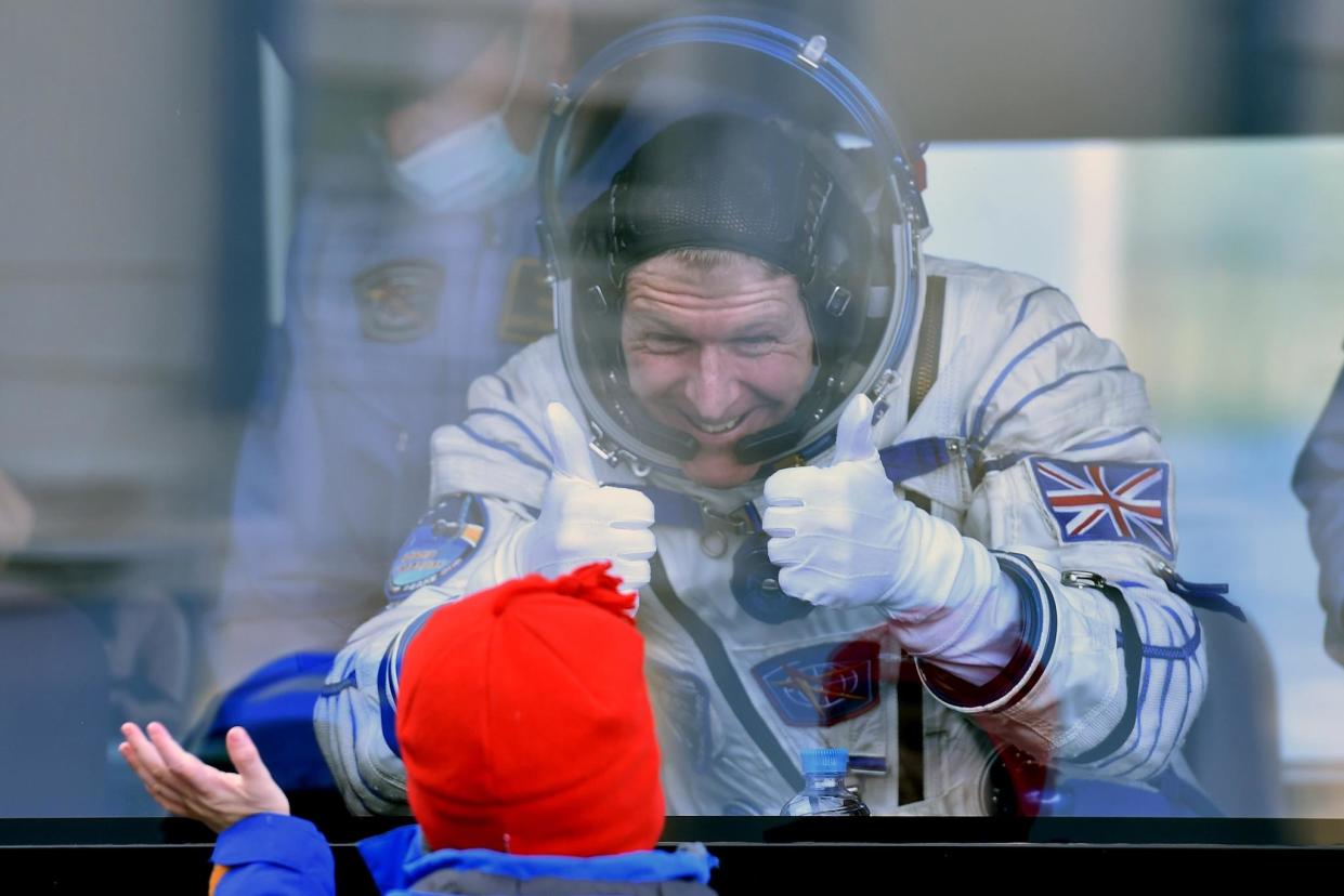 Britain's astronaut Tim Peake gestures to his child from a bus after his space suit was tested at the Russian-leased Baikonur cosmodrome, prior to blasting off to the International Space Station: KIRILL KUDRYAVTSEV/AFP/Getty Images