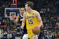 Los Angeles Lakers guard Austin Reaves (15) dribbles the ball as Memphis Grizzlies guard Desmond Bane defends during the first half of an NBA basketball game Wednesday, March 27, 2024, in Memphis, Tenn. (AP Photo/Brandon Dill)