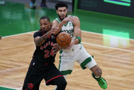 Toronto Raptors guard Norman Powell (24) and Boston Celtics forward Jayson Tatum battle for the ball during the first half of an NBA basketball game, Thursday, March 4, 2021, in Boston. (AP Photo/Charles Krupa)