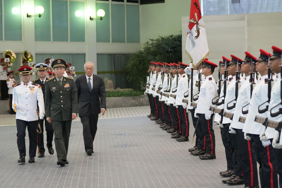 Chinese Defense Minister Gen. Li Shangfu, front center, inspects the honor guard with Singapore Defense Minister Ng Eng Hen, right, in Singapore, Thursday, June 1, 2023. China and Singapore laid the groundwork Friday for a hotline between the two countries that would establish a high-level communications link between Beijing and a close American partner in Asia at a time when Chinese tensions with Washington are high and dialogue has stalled. (AP Photo/Vincent Thian)