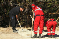 A South Yorkshire police officer (L) and members of the Greek rescue service (in red uniforms) investigate the ground while excavating a site during an investigation for Ben Needham, a 21-month-old British toddler who went missing in 1991, on the island of Kos, Greece, September 27, 2016. REUTERS/Vassilis Triandafyllou
