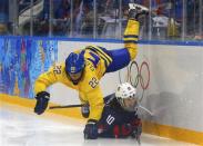 Sweden's Emma Eliasson falls over Team USA's Meghan Duggan during the third period of their women's semi-final ice hockey game at the 2014 Sochi Winter Olympics, February 17, 2014. REUTERS/Brian Snyder
