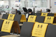 A passenger sits on a socially-distanced chair as he waits to board a plane at the Incheon International Airport In Incheon, South Korea, Wednesday, Dec. 1, 2021. South Korea's daily jump in coronavirus infections exceeded 5,000 for the first time since the start of the pandemic, as a delta-driven surge also pushed hospitalizations and deaths to record highs. (AP Photo/Ahn Young-joon)