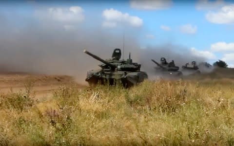 Tanks roll during the military exercises in the Chita region, Eastern Siberia, on Tuesday - Credit: AP/Russia War Games